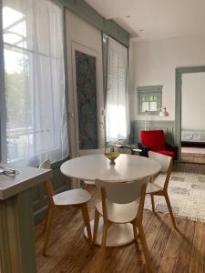 - un salon avec une table et des chaises blanches dans l'établissement CHACHACHA appartement de charme calme balcon 5pers 4étoiles, à Mulhouse