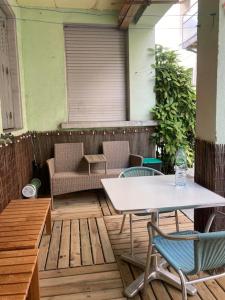 une terrasse couverte avec une table blanche et des chaises. dans l'établissement CHACHACHA appartement de charme calme balcon 5pers 4étoiles, à Mulhouse