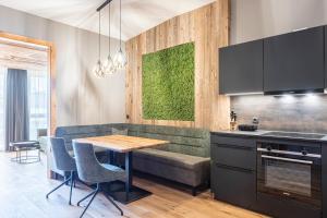 a kitchen with a table and chairs and a couch at Zillertal Suites Fügen by ALPS RESORTS in Fügen