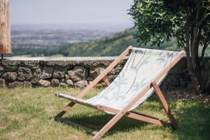 einem Holzstuhl, der im Gras neben einer Steinmauer sitzt in der Unterkunft La Chomotte in Saint-Alban-dʼAy