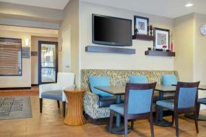 a restaurant with a table and chairs and a flat screen tv at Hampton Inn Merrillville in Merrillville