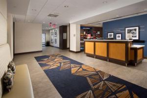 Hampton Inn & Suites Falls Church في فولز تشيرش: لوبي مكتب مع مكتب استقبال وسجادة