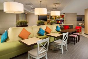 een restaurant met een bank en tafels en stoelen bij Home2 Suites by Hilton Arundel Mills BWI Airport in Hanover