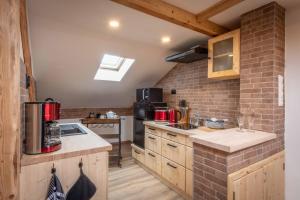 une cuisine avec des placards en bois et un mur en briques dans l'établissement Ski-Bike-Apartment Bayerwald, à Lohberg