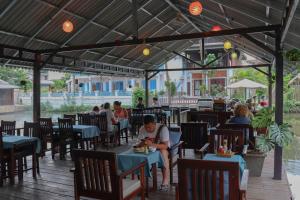 un groupe de personnes assises à table dans un restaurant dans l'établissement Villa Oasis, à Luang Prabang