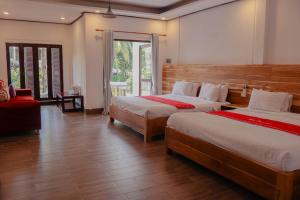 - une chambre avec 2 lits et une grande fenêtre dans l'établissement Villa Oasis, à Luang Prabang