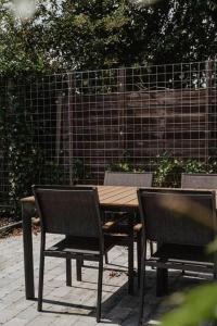 a wooden table and two chairs next to a fence at Life & Cooking Holiday Home in Ermelo