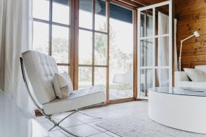 a white chair in a room with a glass table at Life & Cooking Holiday Home in Ermelo