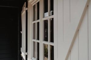 an open window on a white house with a door at Life & Cooking Holiday Home in Ermelo