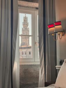 een slaapkamer met een raam met uitzicht op een gebouw bij GRANDE HOTEL PARIS by STAY HOTELS in Porto