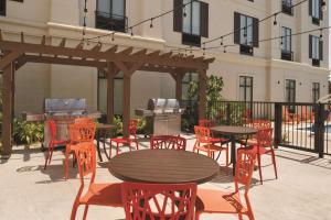 un patio con mesas, sillas y una parrilla en Home2 Suites by Hilton Parc Lafayette, en Lafayette