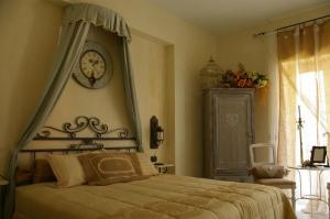 a bedroom with a bed with a clock on the wall at Serapo Bed and Breakfast in Gaeta