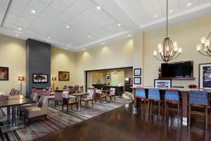 a restaurant with tables and chairs and a flat screen tv at Hampton Inn & Suites Mt. Prospect in Mount Prospect