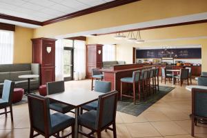 Hampton Inn Indianapolis Northwest - Park 100 في انديانابوليس: مطعم بطاولات وكراسي وبار