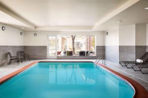 uma piscina com água azul numa casa em Hilton Garden Inn Providence Airport/Warwick em Warwick