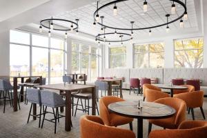 um restaurante com mesas, cadeiras e janelas em Hilton Garden Inn Providence Airport/Warwick em Warwick