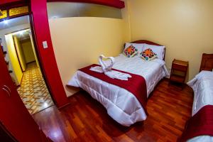 a bedroom with a bed with a bow on it at Hostal Mirador Korichaska in Puno