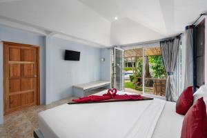 um quarto com uma cama com um laço vermelho em Avocado Koh Samui em Bophut 