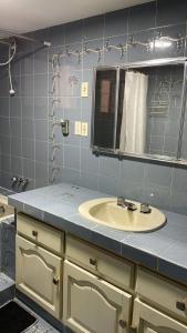 a bathroom with a sink and a mirror at Habitaciones Frente Club Tenis in Cochabamba