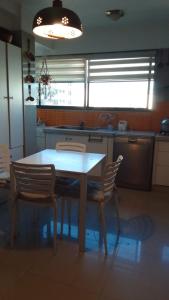 a kitchen with a table and chairs in a kitchen at Habitaciones Frente Club Tenis in Cochabamba