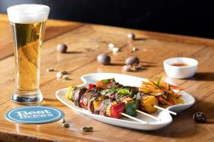 un plato de comida junto a un vaso de cerveza en Four Points by Sheraton Jakarta Thamrin en Yakarta