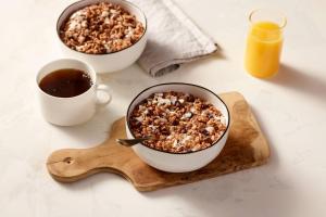 dos tazones de cereales y café sobre una tabla de madera en Four Points by Sheraton Jakarta Thamrin en Yakarta