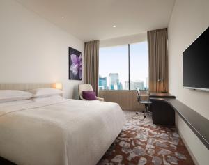 Habitación de hotel con cama grande y TV en Four Points by Sheraton Jakarta Thamrin en Yakarta