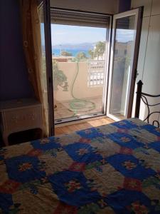 - une chambre avec un lit et une vue sur une terrasse dans l'établissement Κορινθιακός, à Corinthe