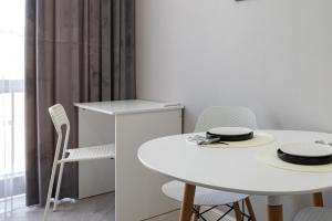 a white dining room with a white table and chairs at Апартаменты бизнес-класса в ЖК 4YOU in Almaty