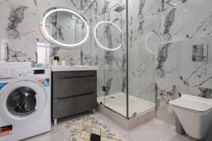 a bathroom with a washing machine and a washer at Апартаменты бизнес-класса в ЖК 4YOU in Almaty