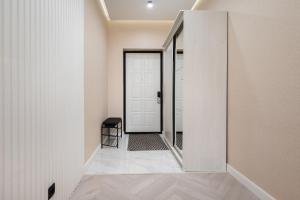 a hallway with a white door and a stool at Апартаменты бизнес-класса в ЖК 4YOU in Almaty