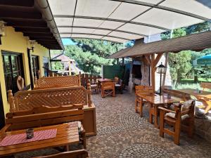 un restaurant avec des bancs, des tables et des tables en bois dans l'établissement Landgasthof Plohnbachtal UG, à Abhorn