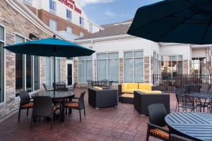 an outdoor patio with tables and chairs and umbrellas at Hilton Garden Inn Cincinnati/Mason in Mason