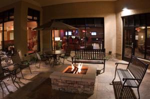 a fire pit in a patio with chairs and a table at Hilton Garden Inn Milwaukee Airport in Milwaukee