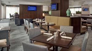 un restaurant avec des tables et des chaises ainsi qu'un bar dans l'établissement DoubleTree by Hilton Chicago Schaumburg, à Schaumburg