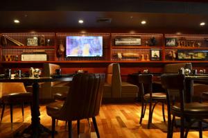 um restaurante com um bar com mesas e cadeiras em Hilton Providence em Providence