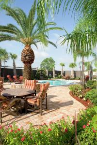 un patio con tavolo, sedie e palma di Hampton Inn I-10 & College Drive a Baton Rouge