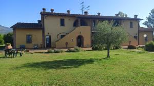 una casa grande con un árbol en un patio en il Chiassetto Agriturismo No Kids, en Cascina