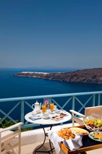 een tafel met eten en drinken op een balkon bij Absolute Bliss in Imerovígli