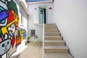 eine Treppe mit Wandmalereien an der Seite eines Hauses in der Unterkunft Wonderland House Leiria in Leiria