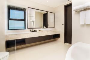 bagno con lavandino e specchio di Grand Palazzo Hotel - SHA Extra Plus a Centro di Pattaya