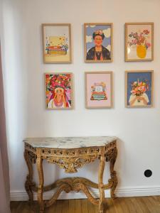 een tafel in een kamer met foto's aan de muur bij Le petit Versailles - T2 au centre-ville in Grenoble