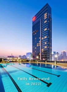 une piscine en face d'un grand bâtiment dans l'établissement Sheraton Guangzhou Hotel, à Canton