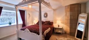 een slaapkamer met een hemelbed en een spiegel bij LOCH NESS - Luxury Highland Retreat in Scotland in Fort Augustus