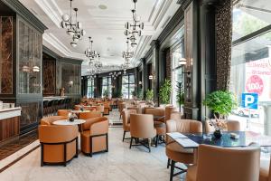 a restaurant with a row of tables and chairs at Hotel Balkan in Belgrade