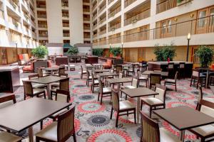 eine leere Cafeteria mit Tischen und Stühlen in einem Gebäude in der Unterkunft Embassy Suites by Hilton Chicago O'Hare Rosemont in Rosemont