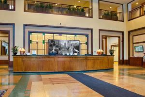 ein Hofzimmer mit einem großen Holzschreibtisch in einem Gebäude in der Unterkunft Embassy Suites by Hilton Chicago O'Hare Rosemont in Rosemont