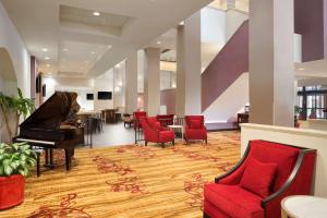 eine Lobby mit einem Klavier und roten Stühlen in der Unterkunft Hilton Fort Wayne at the Grand Wayne Convention Center in Fort Wayne