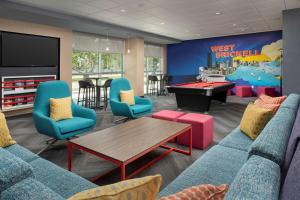 a waiting room with a couch and a ping pong table at Tru By Hilton Miami West Brickell in Miami