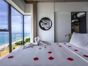 a bedroom with a bed with red roses on it at ibis Styles Maceió Pajuçara in Maceió